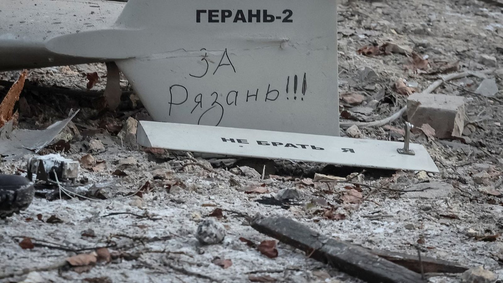 Débris d'un drone d'attaque portant l'inscription « Герань-2 » sur l'empennage, au sol parmi des gravats